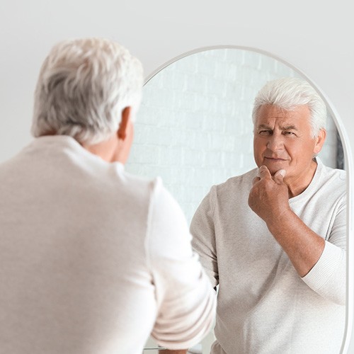 Dentures patient in Naples looking in the mirror